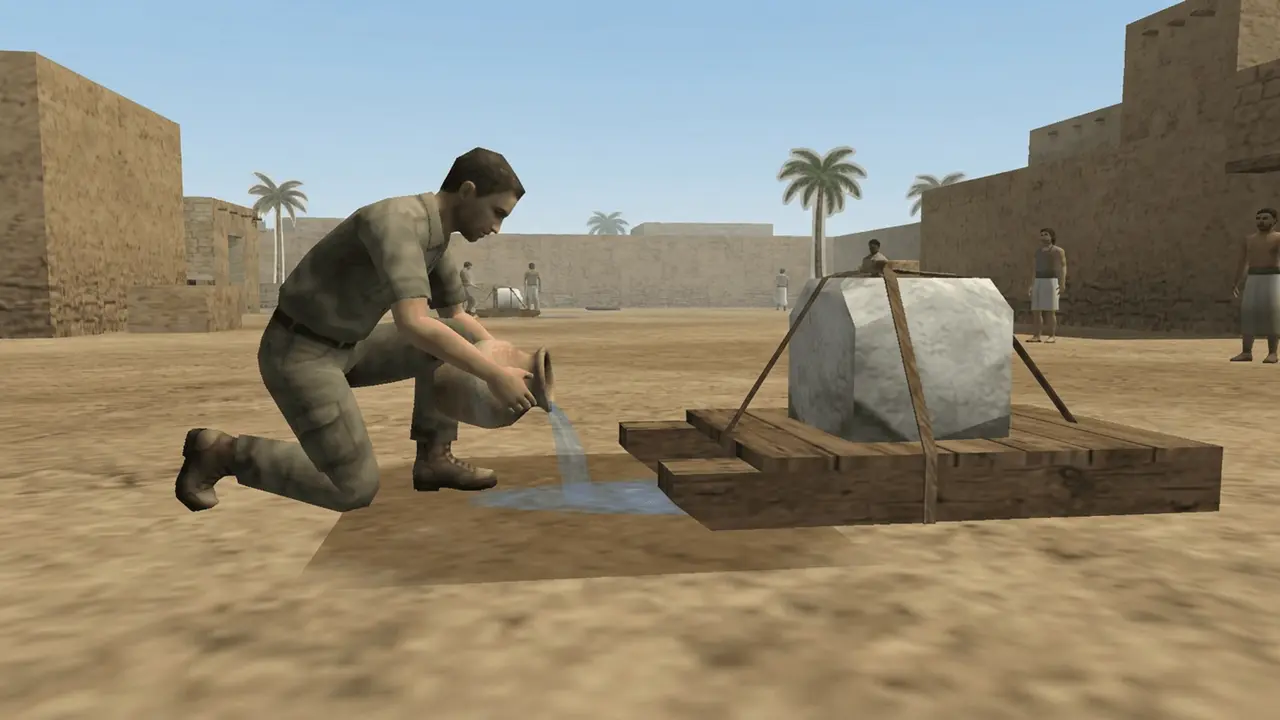 A man pours water on the sand in front of a sledge carrying a stone block
